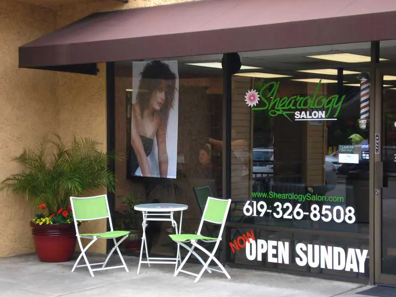 Shearology's original storefront in Rancho Mission Plaza with its maroon awning and green chairs